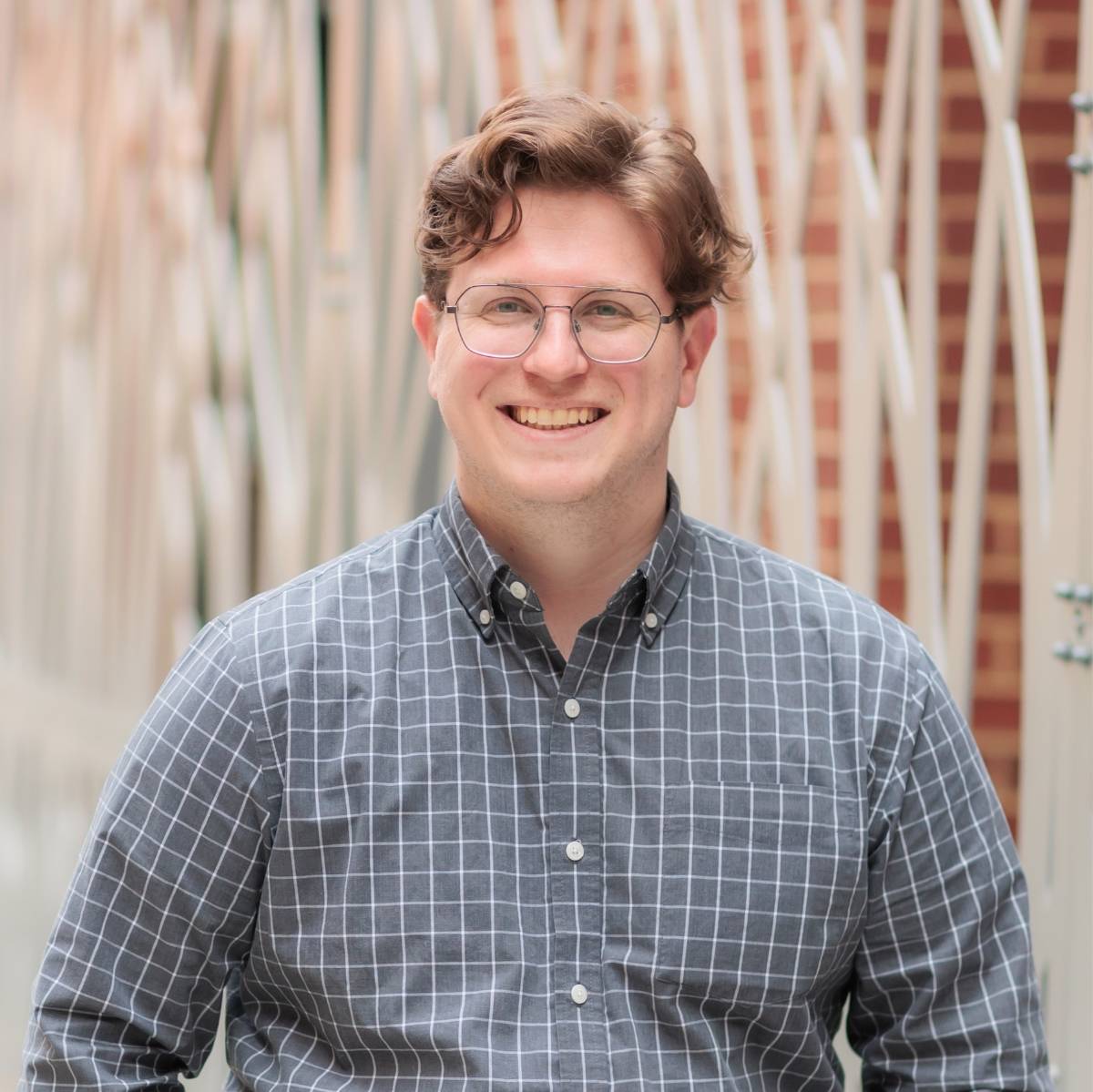 JD Allen posing in front of a fence