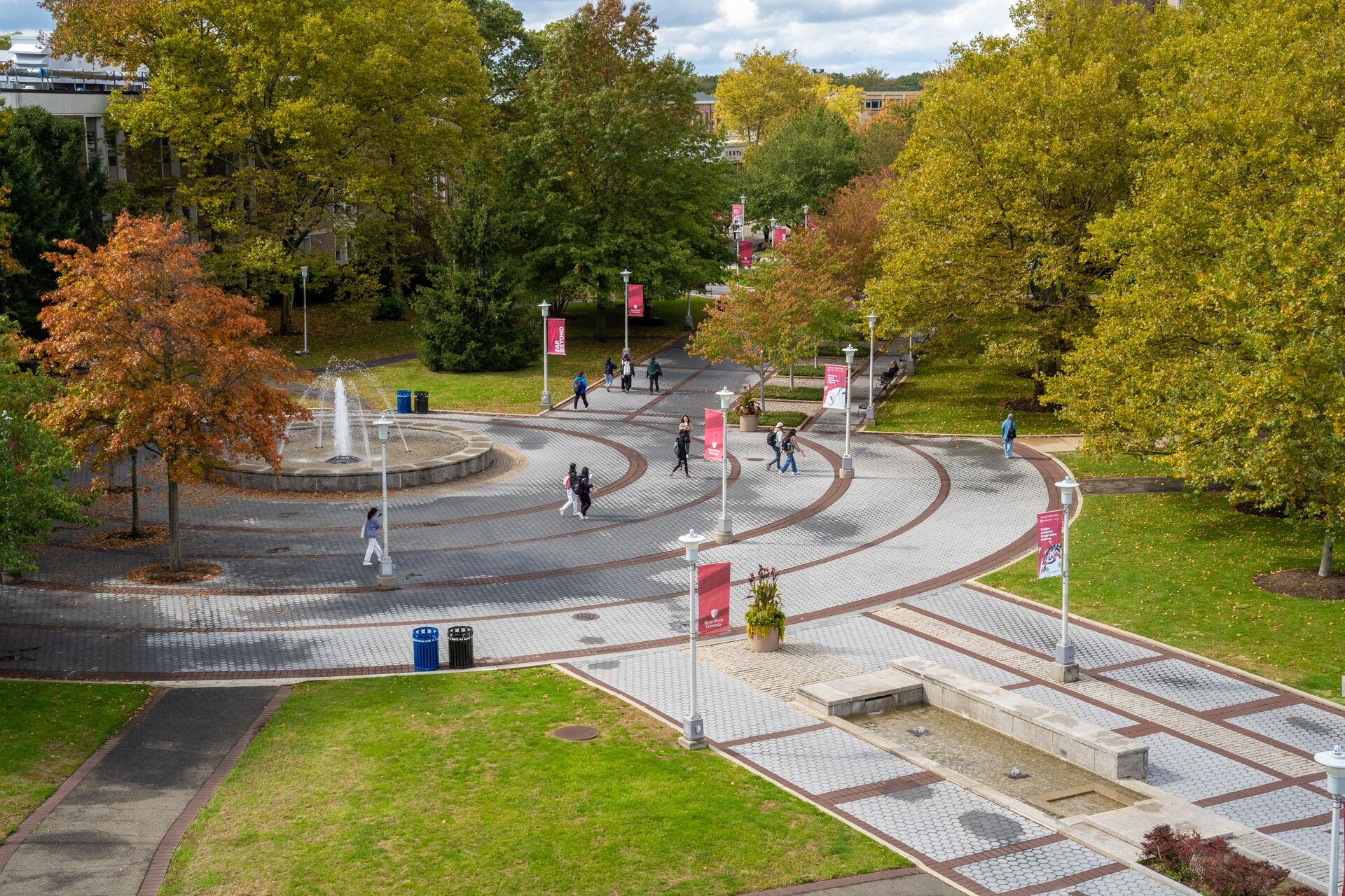 photo of an outdoor fountain on stony brook university's campus with students walking around it