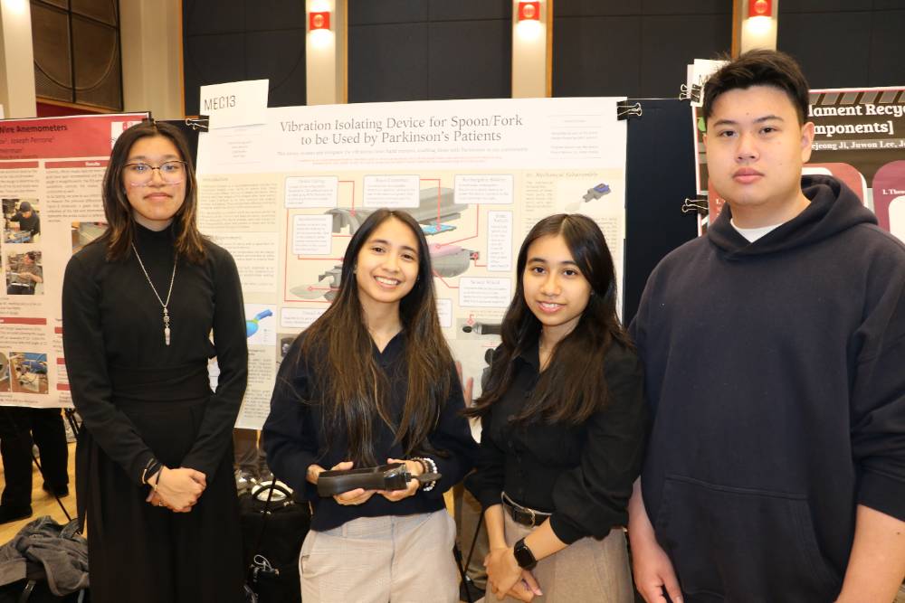 Four students standing in front of research board with new spoon design