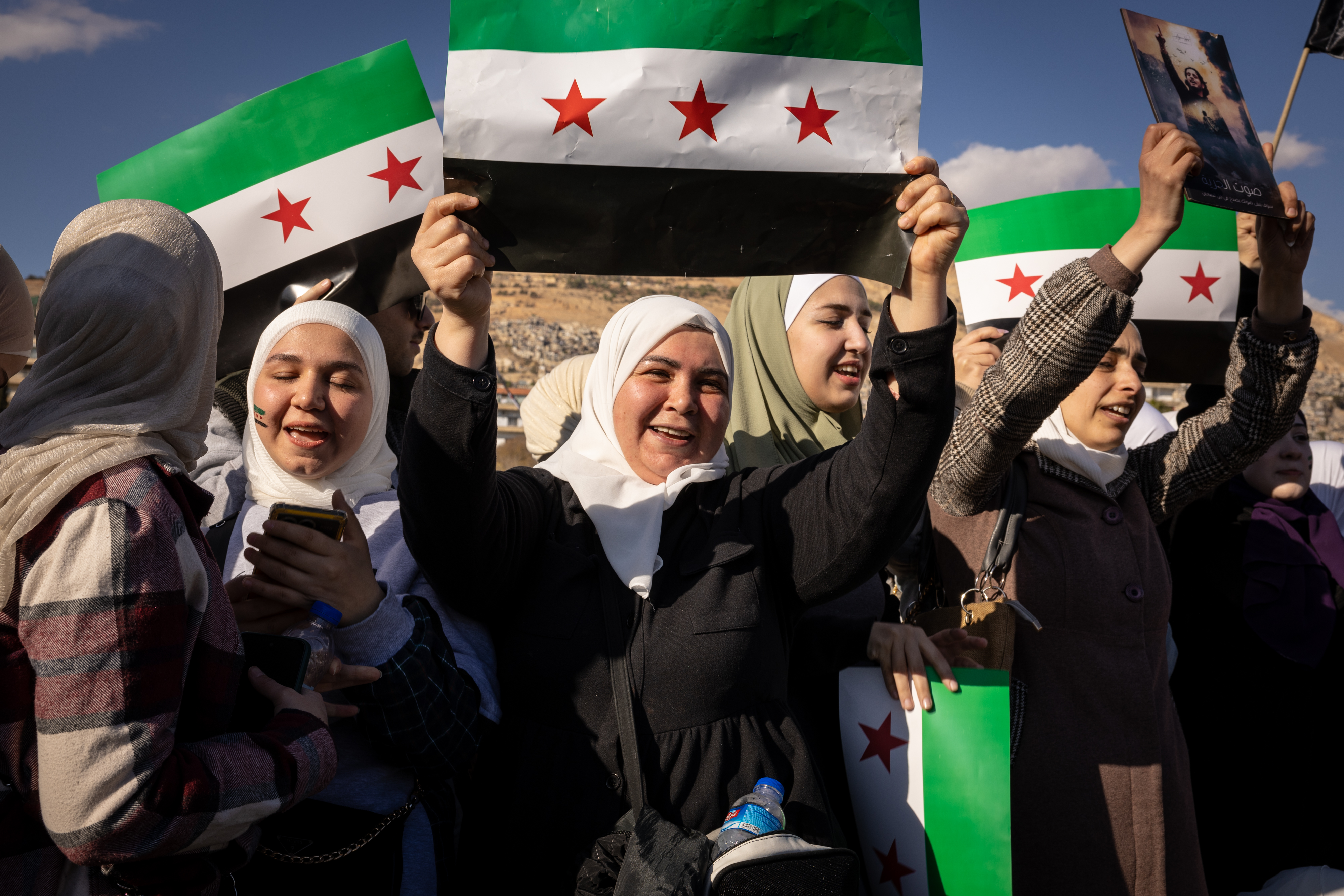 Syrians celebrate the end of the Assad regime waving the Syrian revolutionary flag