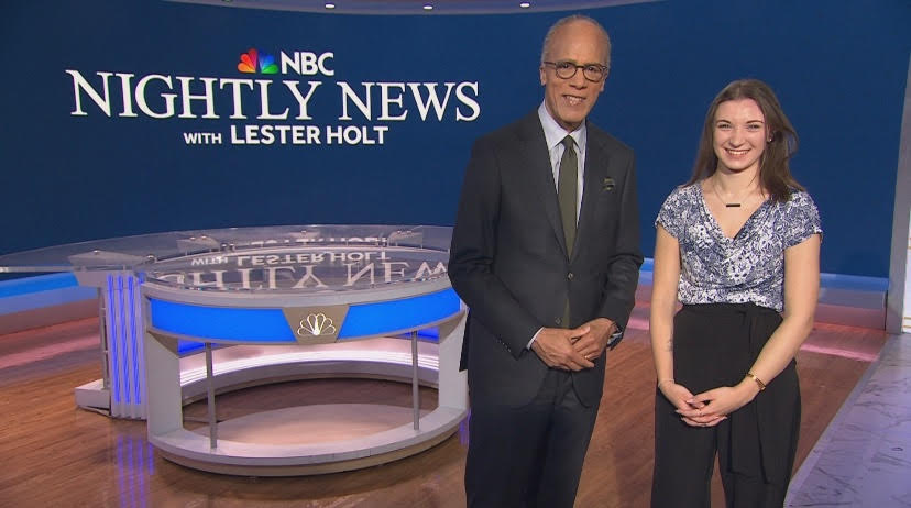 Viola Flowers and Lester Holt stand next to the NBC Nightly News desk on set
