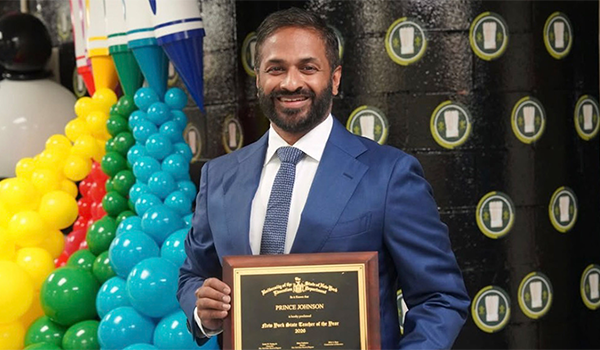 Prince Johnson poses with his award plaque